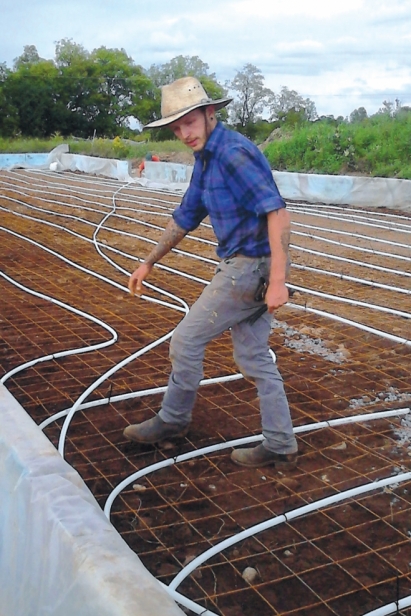 Piotr Pawlowski, a member of the Bluegrass Farm team, installs tubing for the radiant-heat system.