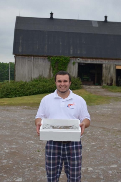Behind Edible Ottawa's Cover: Brad Cocchio poses with shrimp raised in converted hog barns in Campbellford, Ont.